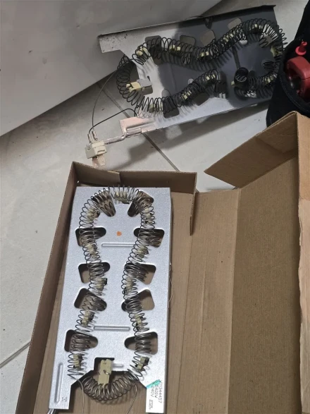 Old Samsung dryer heating element beside the new element in its box